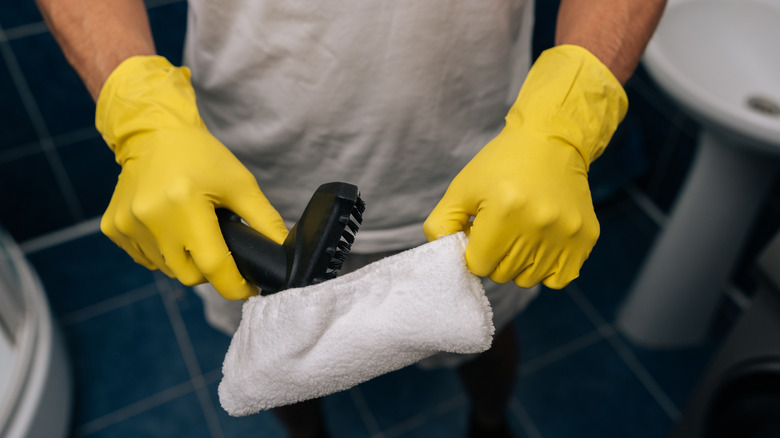 person holding microfiber cloth attachment above various sizes of other microfiber cloth attachments