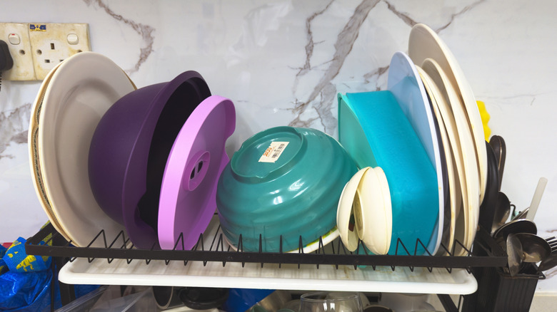 A dish drying rack overflowing with dishes