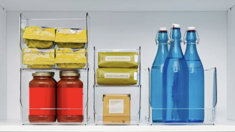 Stacking bins holding bottles, cans, and food packages