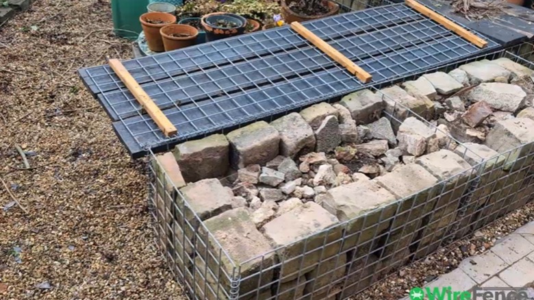 gabion bench outside filled with rocks, with lid open