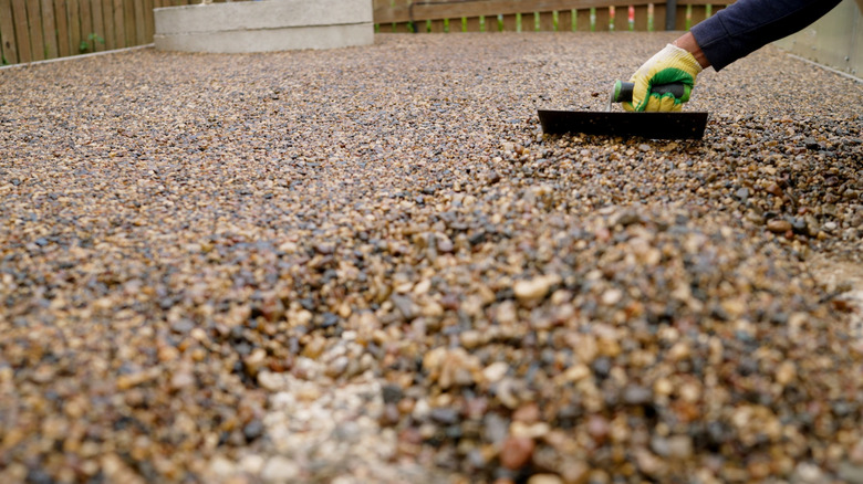 A hand laying a resin bound patio