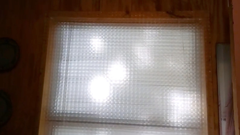 A window sealed with an opaque, textured shower curtain