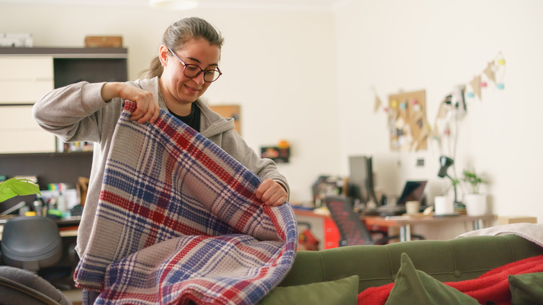 A woman handling a blanket at home