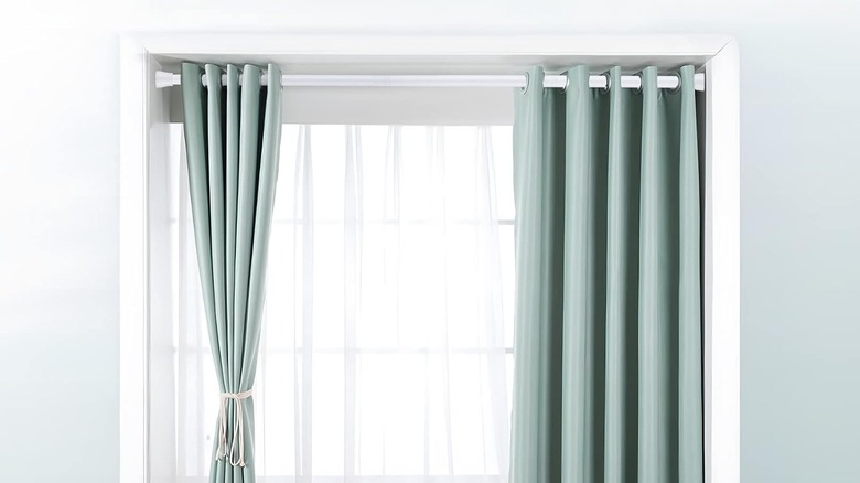 Curtains hung tightly to a window with a white tension rod