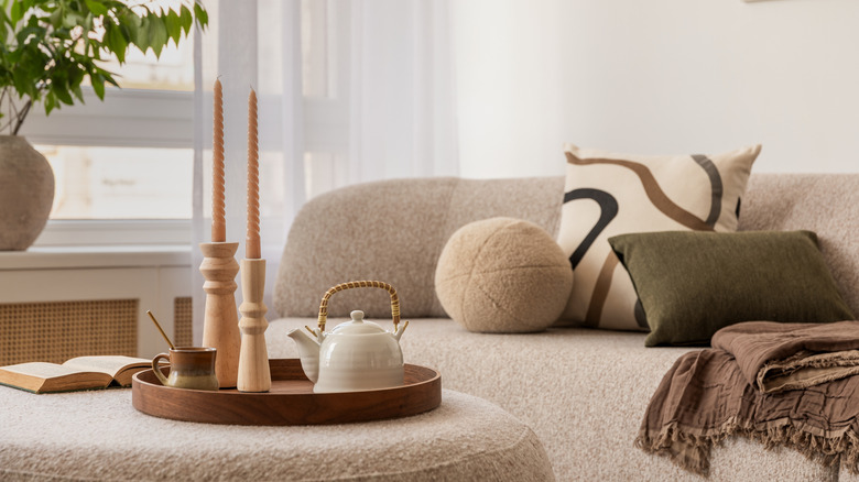 earthy tone living room setup with rounded sofa and ottoman