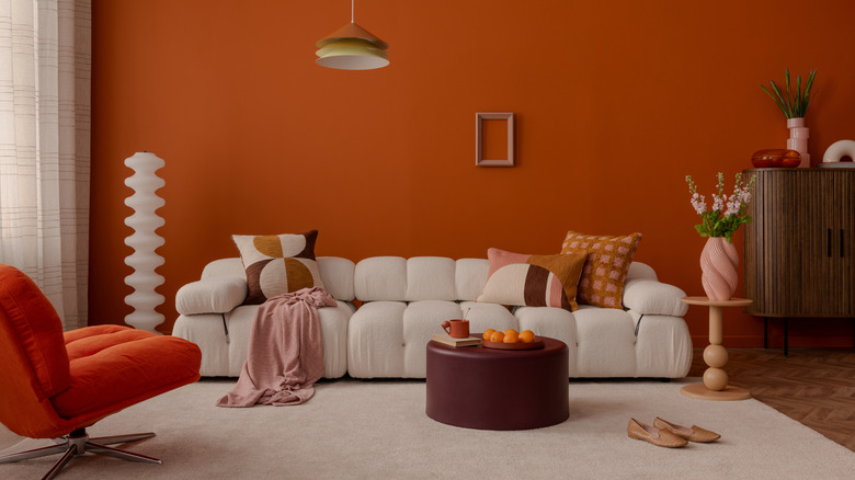 orange room with unique sculptural sofa and colorful decor