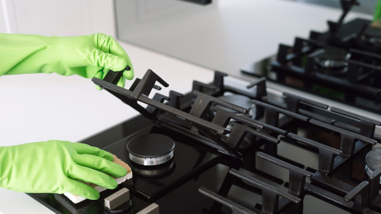 Close-up of a person cleaning stovetop grates