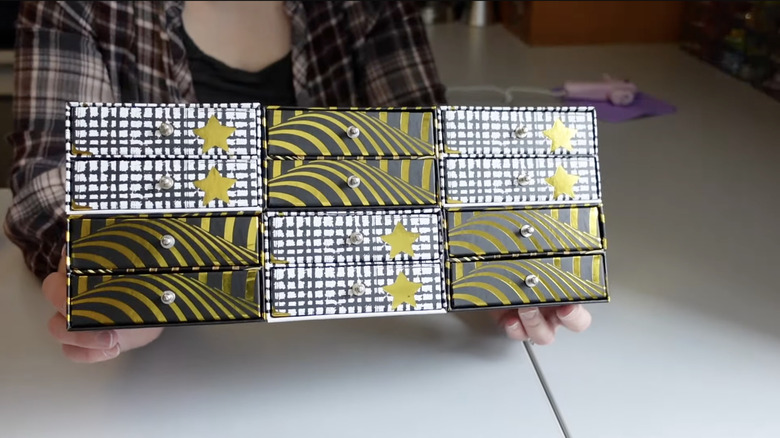 A DIY gold and white jewelry box with silver knobs