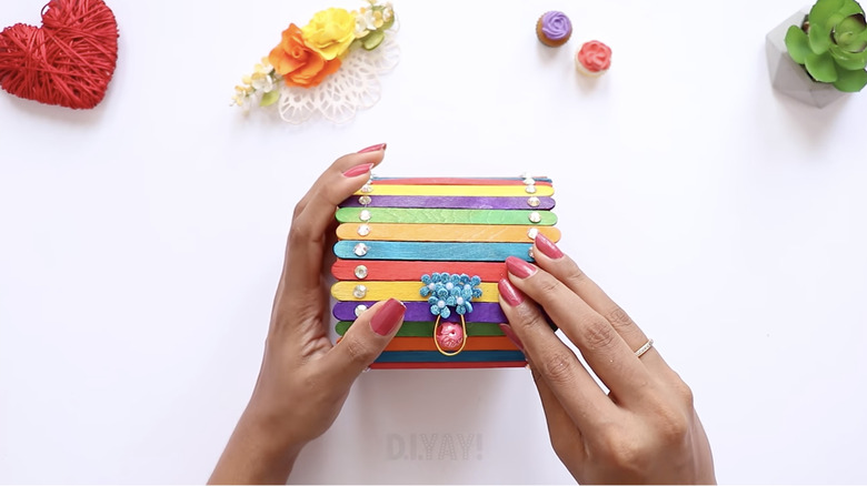 A round jewelry box made from rainbow popsicle sticks