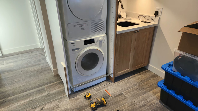 An IKEA SEKTION being installed in a bathroom to hide a washer and dryer.