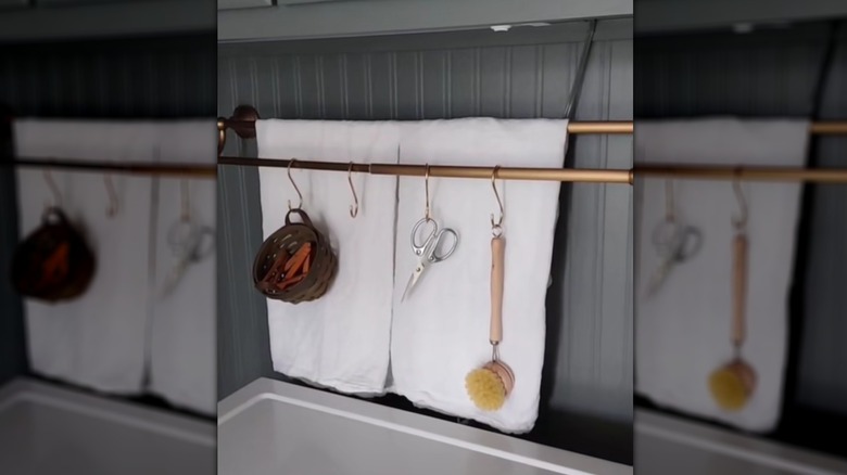 A towel rack hides an ugly wall in a laundry room.
