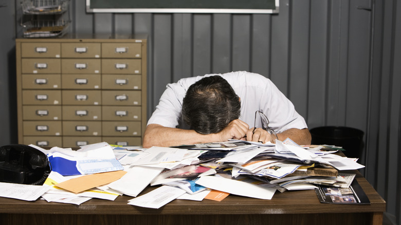 Guy with his head on a stack of mail