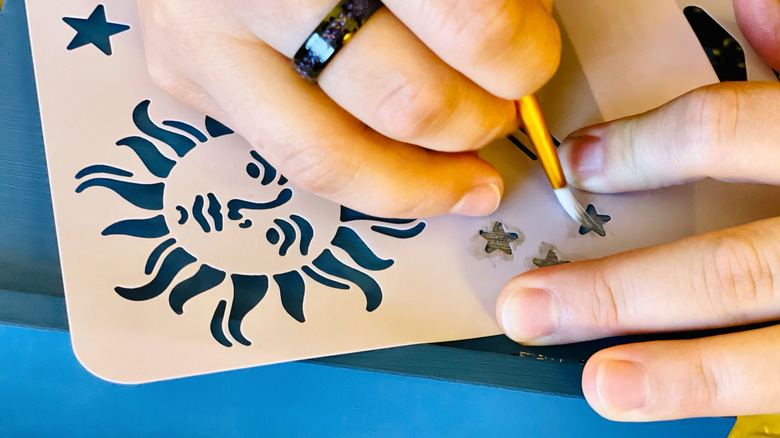 Person painting a stencil
