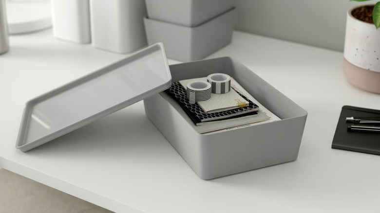 A gray KUGGIS box with washi tape and notebooks inside on a counter