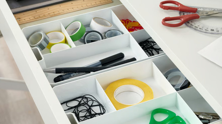 KUGGIS insert with 5 compartments in a drawer with stationary like pens, tape, and scissors