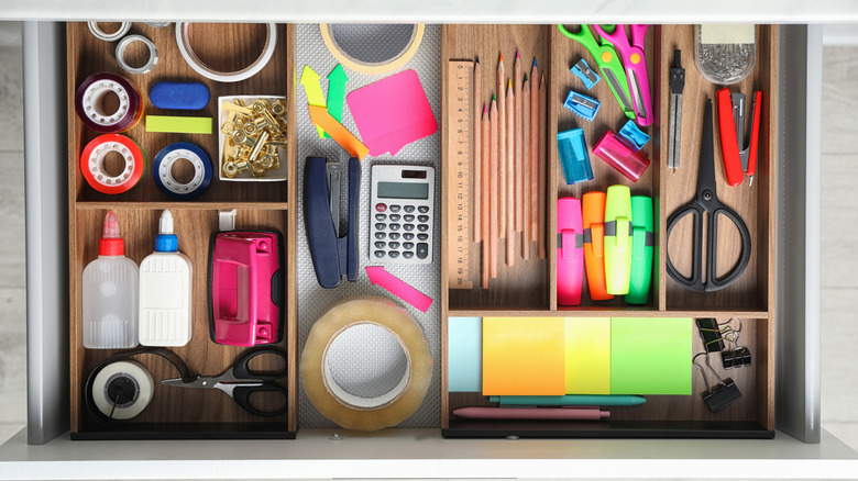 An above view of colorful stationary mostly organized into different compartments