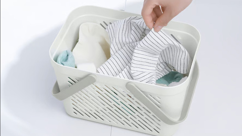 A RÅNEN basket on a white background with small fabrics inside