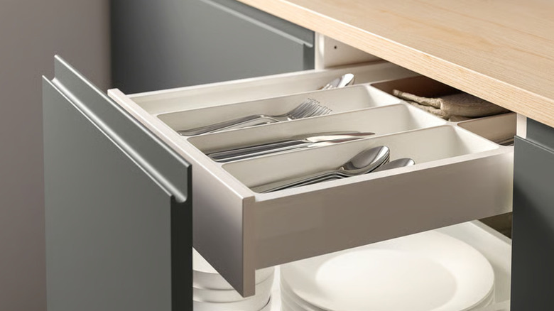 The UPPDATERA flatware tray with silverware inside of a kitchen drawer