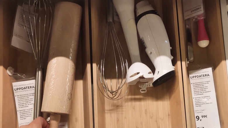 An UPPDATERRA utensil tray in the store with kitchen items such as a rollin gpin, immersion blender, and a whisk inside