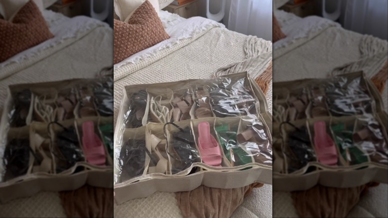A under-the-bed shoe organizer packed with shoes while on the bed