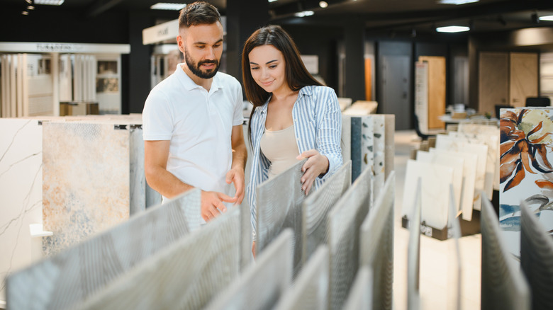 Married couple chooses ceramic tiles for kitchen or bath at a hardware store.