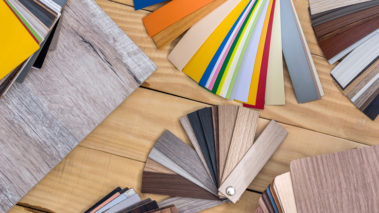 A series of samples of different flooring options on a wood floor