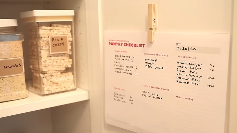 Clothespin holding a pantry checklist on inner wall of pantry next to storage containers