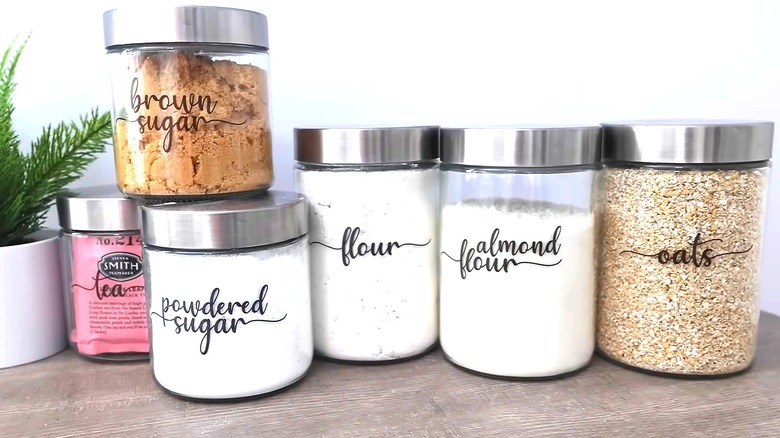 Glass jars holding pantry stables with black labels on them