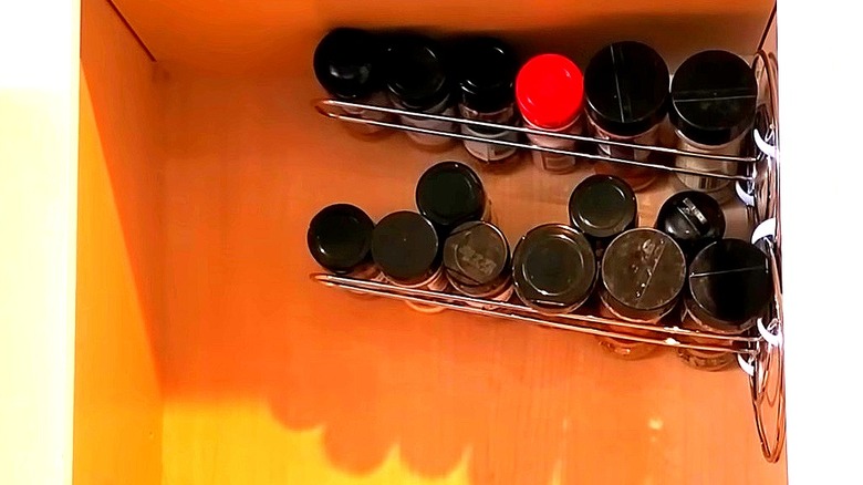 Two Dollar Tree paper towel holders attached to side of pantry, filled with spices