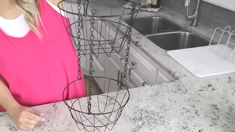 Creator holding a two-tiered hanging basket storage solution