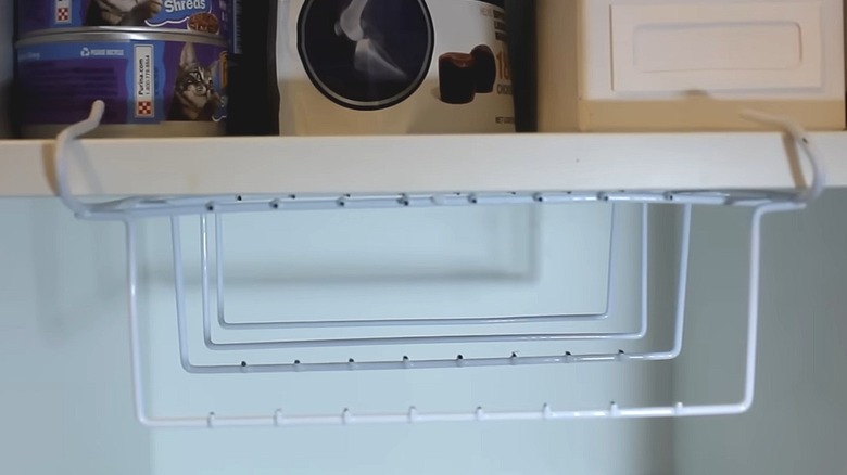 Dollar Tree shower caddy with shelves removed, hooked onto a pantry shelf
