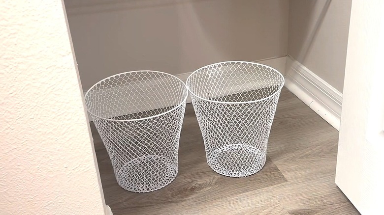 Two Dollar Tree wire trash bins in the bottom of a pantry