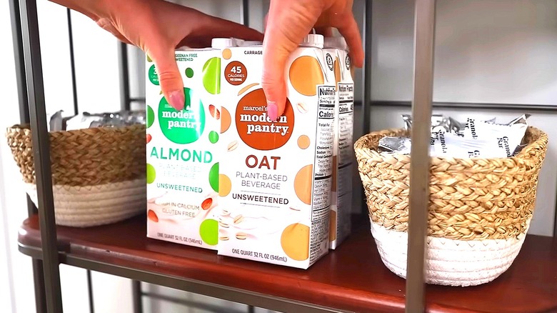 Person placing shelf-stable milk between two baskets filled with snacks