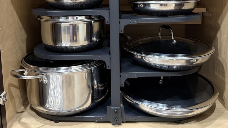 Fovkdcvw's Heavy-Duty Pots and Pans Organizer loaded with cookware in a kitchen cabinet