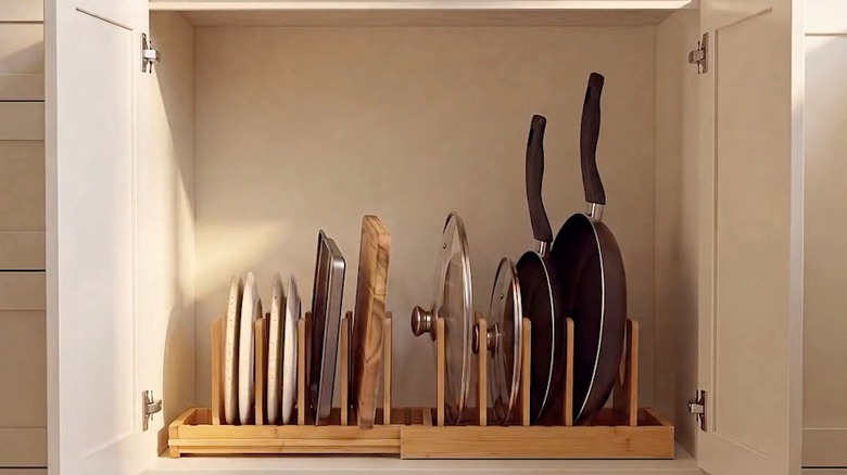 INMAKER's Under Cabinet Pots and Pans Organizer in use as pot lid storage inside a cabinet