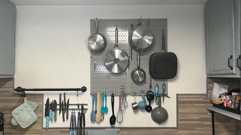 Pans and cooking utensils hung from Wall Control's Kitchen Pegboard Organizer