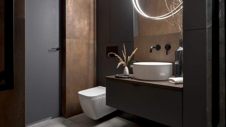 Modern bathroom with rusty tiles, stylish lighting and elegant decorations