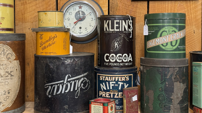 Obsolete tins and cans used to sell and store pantry items for sale at an antique store.
