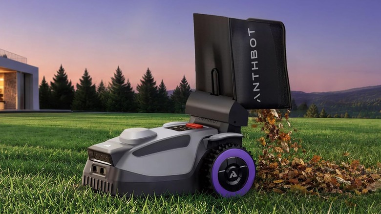 The ANTHBOT N8 mowing a lawn while its bag dumps captured leaves out of the back