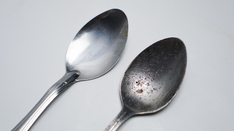 One clean spoon and one rusty spoon side by side