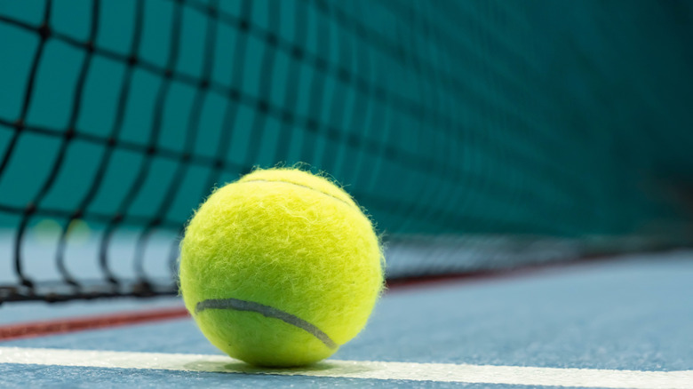 Tennis ball on blue tennis court