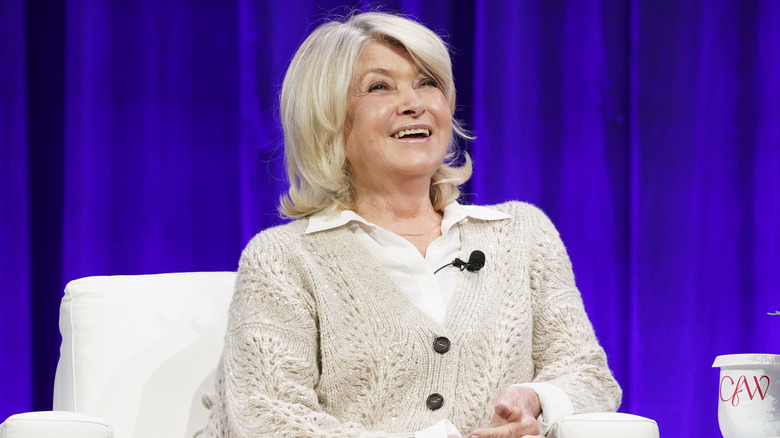 Martha Stewart laughing against a purple backdrop