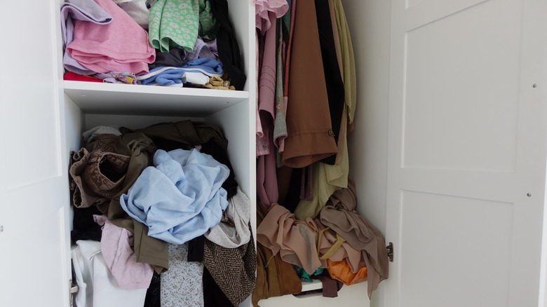 A messy closet full of clothing