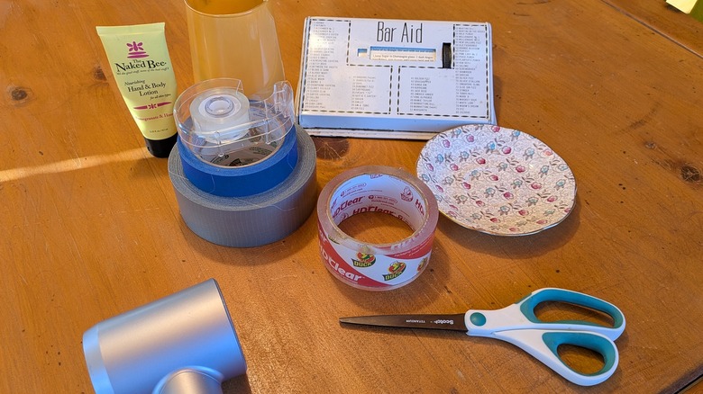 Various items with price tags, rolls of tape, and a hairdryer on a table