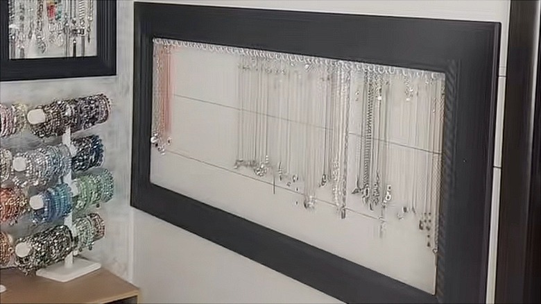 Black frame with hooks holding necklaces