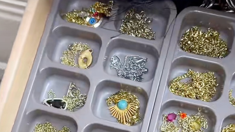 Closeup of ice cube tray with necklaces inside