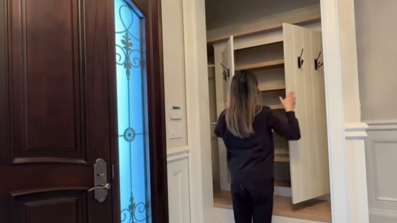 Woman opens hidden cupboards in the entry nook