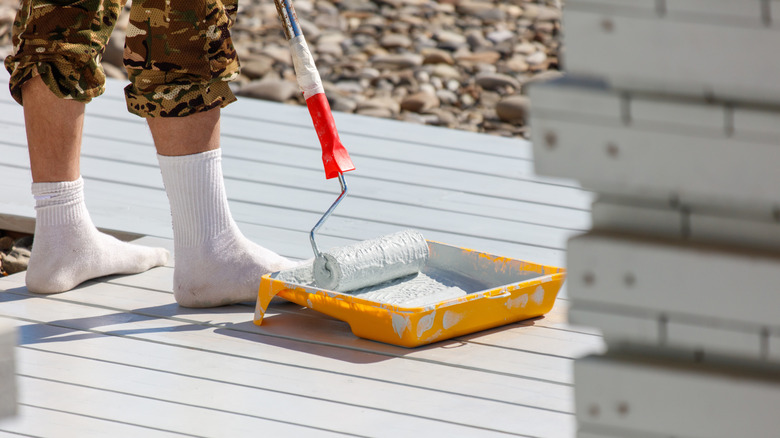 A person painting a patio white