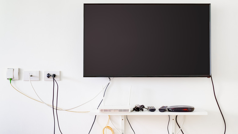 a wall-mounted TV with messy cords