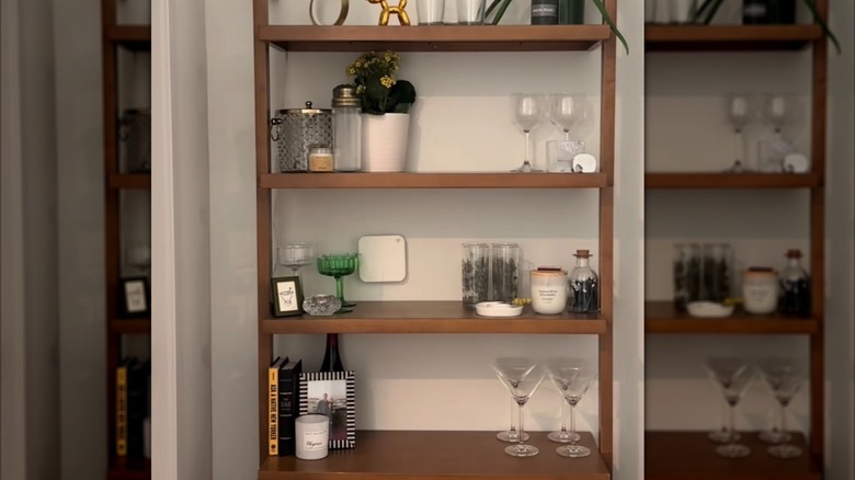 Bookshelf with bar glasses and accessories on it